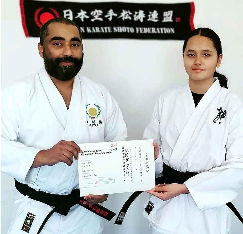 Sensei Najmal Ibrahim presenting a Japan Karate Shoto Federation (JKS) certificate to a female black belt student